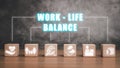 Wooden block on desk with work life balance icon on virtual screen