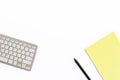 Work office desk with a keyboard, a yellow notepad and a black p Royalty Free Stock Photo