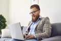 Work online. Funny bearded man in glasses laughing working online video chat call using laptop at home office.