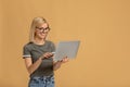 Work opportunities online. Happy lady with laptop computer in hands surfing internet, beige background with empty space