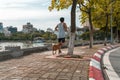 Work out with dog. Asian male running with his dog in the park