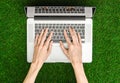 Work outdoors theme: the human hand shows gestures and an open notebook on a background of green grass top view Royalty Free Stock Photo