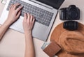 The work of the photographer, photo retouching. Photographic equipment,hat, wallet, female hands typing on laptop keyboard Royalty Free Stock Photo