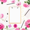 Work place with clipboard, pastel flowers and accessories on white background. Flat lay, top view. Blogger of freelancer concept Royalty Free Stock Photo