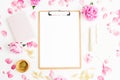 Work place with clipboard, pastel flowers and accessories on white background. Flat lay, top view. Freelancer concept Royalty Free Stock Photo