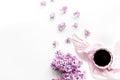 Work place with lilic flowers, coffee and scarf for woman on white desk background top view mock-up