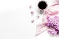 Work place with lilic flowers, coffee and scarf for woman on white desk background top view mock-up