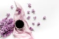 Work place with lilic flowers, coffee and scarf for woman on white desk background top view mock-up