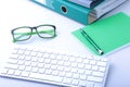 Work place table with folders file on it and modern laptop, pen, glasses and textbook lying near on a white background. Royalty Free Stock Photo