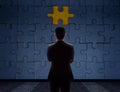 Work Problem Concept. Blurred Back side of a businessman Standing in front of blank Jigsaw Puzzle Wall to Finding a Lost Piece. T Royalty Free Stock Photo