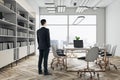 Work process with businessman back view in modern conference room interior design with white table and chairs on golden legs, Royalty Free Stock Photo