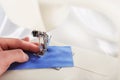 Work in process - sewing machine and hand of tailor with needle, thread and fabric. Item of clothing Royalty Free Stock Photo