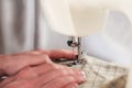 Work in process - sewing machine and hand of tailor with needle, thread and fabric. Item of clothing Royalty Free Stock Photo