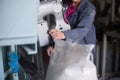 Work on the production of agricultural products. A Caucasian woman dressed in an iniform performs work on a conveyor that packs