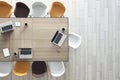 Work in progress concept with top view on wooden meeting table with laptops and coffee mugs surrounded by white, brown and yellow