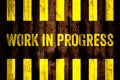 Work in progress warning sign with yellow and black stripes painted over cement concrete wall coarse surface texture background. Royalty Free Stock Photo