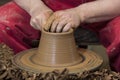 Work with red clay. Male hands form a bowl on a spinning pottery wheel. Royalty Free Stock Photo