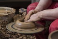 Work with red clay. Male hands form a bowl on a spinning pottery wheel. Royalty Free Stock Photo