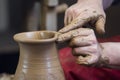Work with red clay. Male hands form a bowl on a spinning pottery wheel. Royalty Free Stock Photo