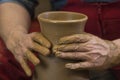 Work with red clay. Male hands form a bowl on a spinning pottery wheel. Royalty Free Stock Photo