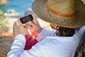 Work & rest: man in hat in a hammock typing on touch phone screen on a summer day Royalty Free Stock Photo