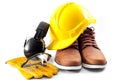 Work safety concept with hard hat, protective gloves, boots, eye safety glasses and hearing protecting noise canceling earmuffs Royalty Free Stock Photo