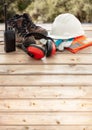 Work safety protection equipment. Industrial protective gear on wooden table, blur construction site background Royalty Free Stock Photo