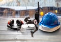 Work safety protection equipment. Industrial protective gear on wooden table, blur construction site background Royalty Free Stock Photo