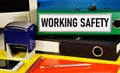 Work safety. Text label on the folder. Monitoring the state of working conditions to reduce injuries and accidents