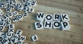 Work shop written in letter tiles wooden background