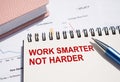 WORK SMARTER NOT HARDER. Text written on notepad with pen on financial documents Royalty Free Stock Photo