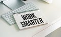 WORK SMARTER text on a paper with magnifier, coffee and keyboard on a white background Royalty Free Stock Photo