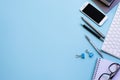 Work space - Creative flat lay photo of workspace desk. Top view office desk with laptop, notebooks, pen and smartphone on blue. Royalty Free Stock Photo