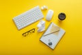 Work space desk layout with note keyboard coffee cup glasses bright color yellow background. Modern office desk work Royalty Free Stock Photo