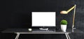 Work space stand mock up with table and plant, computer, keyboard, mouse; cup; sticker front black concrete wall Royalty Free Stock Photo