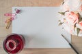 Work space watercolor paper or note paper with red ink,colorful clips,stationery, brush and Bouquet of pink roses on wooden table. Royalty Free Stock Photo