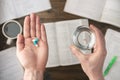 Hands holding pills and glass of water above Workspace desk with pharmaceutical pills Royalty Free Stock Photo