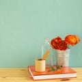 Work and study place. note book, pencil with floral decoration on wooden desk with green background Royalty Free Stock Photo