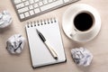 Work table, a cup of coffee, a notebook with a pen and crumpled paper Royalty Free Stock Photo