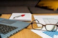 Work table at home with pen, papers, bills, charts, glasses, computer and calculator. Concept work at home, checking accounts,