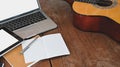 Work table of songwriter. Cropped shot of note, pencil, acoustic guitar, white blank screen tablet and laptop. Royalty Free Stock Photo