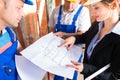 Work Team on construction site controlling floor plan Royalty Free Stock Photo