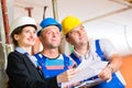 Work Team on construction site controlling floor plan Royalty Free Stock Photo