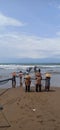 work together to catch fish on the beach