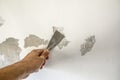 Work tool, putty knife in hand on a white wall background, work plasterer, cleaning the wall of old paint Royalty Free Stock Photo