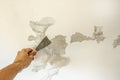 Work tool, putty knife in hand on a white wall background, work plasterer, cleaning the wall of old paint Royalty Free Stock Photo