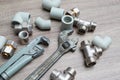 Plumbing concept set of piping accessories plumb adjustable wrenches fittings on wooden background. Plumbing tools and equipment