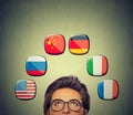 Work and travel opportunity concept. Woman in glasses looking up at icons of international flags