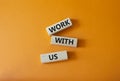 Work with us symbol. Wooden blocks with words Work with us. Beautiful orange background. Business and Work with us concept. Copy