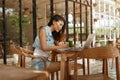 Work. Woman With Laptop At Coffee Shop. Asian Girl In Jeans Outfit Writing In Planner Book At Cafe. Royalty Free Stock Photo